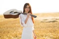 Summer is a great dream time. Beautiful woman with acoustic guitar in field Royalty Free Stock Photo