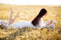 Summer is a great dream time. A young girl in a white dress on the field at sunset. Ripe wheat ears on the field. Early Royalty Free Stock Photo