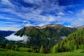 Summer green mountains with blue sky and white clouds. Mountains in the Alps. Mountain scenery in summer. Green meadow with Royalty Free Stock Photo