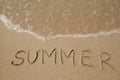 Summer - handwritten on the soft beach sand.