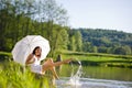 Summer - Happy romantic woman sitting by lake