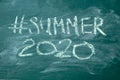 Summer 2020 hashtag it handwritten with white chalk on a green blackboard Royalty Free Stock Photo