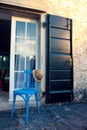 Summer hat on blue chair in front of entrance in Prove