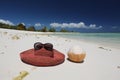 Summer hat and coconut on tropical sandy beach Royalty Free Stock Photo