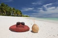 Summer hat and coconut on tropical sandy beach Royalty Free Stock Photo