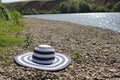Summer hat on the pebble beach isolated