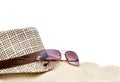 Summer hat with sunglasses on the pile of sand.