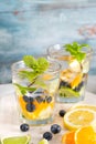 Summer healthy cocktails of citrus infused waters, lemonades or mojitos, with lime lemon orange blueberries and mint, diet detox