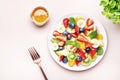 Summer healthy fruit and berry salad with strawberries, blueberries, banana, kiwi, orange and mint leaves, pink background, top Royalty Free Stock Photo
