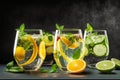 Summer healthy lemonade, cocktails of citrus infused water or mojitos, with lime lemon orange, ice and mint, diet detox beverages