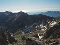 Summer high mountain peaks with blue sky and snow spots