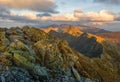 Summer hiking in the mountains with massive rocks, dramatic skies and majestic mountains.