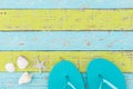 Summer holiday background with beach sandals and seashells on colorful wood Royalty Free Stock Photo