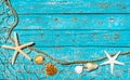 Summer holiday background, maritime fishing net with starfish and seashells on turquoise blue wood Royalty Free Stock Photo