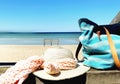 Summer holiday on beach ,women hat with bow beachwear blue jeans on wooden bench sky with white clouds beach with white sand ,