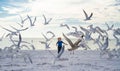 Summer holiday. Child run on the seagulls on the beach, summer time. Cute little boy chasing birds near sea on summer Royalty Free Stock Photo