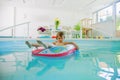 Summer holiday is comming. Happy little child girl playing in water with colorful child boat in swimming pool Royalty Free Stock Photo
