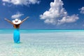 Woman stands in tropical, turquoise waters and enjoys her vacation Royalty Free Stock Photo