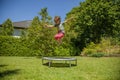 Summer holiday concept. Little cute child girl having fun outdoors and she jumping on a trampoline Royalty Free Stock Photo