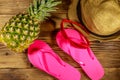 Summer holiday concept. Pineapple, straw hat, flip flops and sunglasses on wooden background Royalty Free Stock Photo