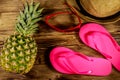 Summer holiday concept. Pineapple, straw hat, flip flops and sunglasses on wooden background Royalty Free Stock Photo