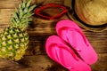 Summer holiday concept. Pineapple, straw hat, flip flops and sunglasses on wooden background Royalty Free Stock Photo