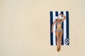 Summer holiday fashion concept - tanning girl wearing sun hat at the beach on a white sand shot from above.Top view from drone. Royalty Free Stock Photo