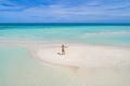 Summer holiday fashion concept - tanning girl wearing sun hat at the beach on a white sand shot from above.Top view from drone. Royalty Free Stock Photo