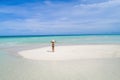 Summer holiday fashion concept - tanning girl wearing sun hat at the beach on a white sand shot from above.Top view from drone. Royalty Free Stock Photo