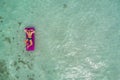 Summer holiday fashion concept - tanning man at the beach on a turquoise sea shot from above. Top view from drone. Aerial view of Royalty Free Stock Photo