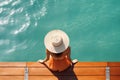 Summer holiday fashion concept - tanning woman wearing sun hat on a wooden pier view from above Royalty Free Stock Photo