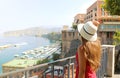 Summer holiday in Italy. Back view of young woman holding her hat with Sorrento village and harbor on the background, Sorrentine Royalty Free Stock Photo