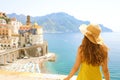 Summer holiday in Italy. Back view of young woman with straw hat and yellow dress with Atrani village on the background Royalty Free Stock Photo