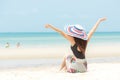 Summer Holiday. Lifestyle woman chill big white hat and wearing bikini fashion summer trips sitting on the sandy ocean beach. Royalty Free Stock Photo