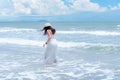 Summer Holiday. Lifestyle woman white dress wearing fashion summer trips walking on the sandy ocean beach. Happy woman enjoy and r