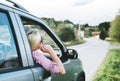 Summer holiday roadtrip travel to countryside. Young hipster blond woman driving car on rural road and having fun summer vacation Royalty Free Stock Photo
