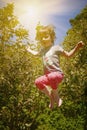 Summer holiday, sport, rest, happy childhood concept. Little cute child girl having fun outdoors and she jumping on a trampoline Royalty Free Stock Photo