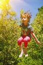 Summer holiday, sport, rest, happy childhood concept. Little cute child girl having fun outdoors and she jumping on a trampoline. Royalty Free Stock Photo