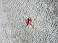 Woman wearing sun hat at the beach on white sand. Top view from drone. Aerial view of slim woman sunbathing lying on beach. Royalty Free Stock Photo