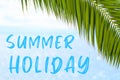 Summer Holiday text on the background with palm leaf and blue sea. Template of a greeting card, postcard or Royalty Free Stock Photo