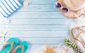 Summer holiday, travel and vacation concept. Sunglasses, starfish, beach hat, flip flop and sea shell on pastel blue wooden Royalty Free Stock Photo