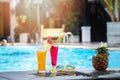 Summer holiday tropical concept. Fresh orange juice and watermelon juice and pineapple on border of a swimming pool Royalty Free Stock Photo