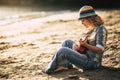 Summer holiday vacation for artist hippy lifestyle independent people beautiful blonde woman sitting on the sand with coloured