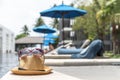 Summer holiday vacation relaxation at resort hotel swimming pool with hat and sunglasses to protect from UV sunlight Royalty Free Stock Photo