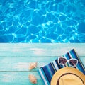 Summer Holidays in Beach Seashore. Fashion accessories summer flip flops, hat, sunglasses on bright turquoise board near the pool