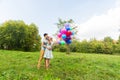 Summer holidays, celebration and dating concept - couple with colorful balloons in nature Royalty Free Stock Photo