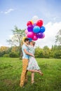 Summer holidays, celebration and dating concept - couple with colorful balloons in nature Royalty Free Stock Photo