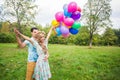 Summer holidays, celebration and dating concept - couple with colorful balloons in nature Royalty Free Stock Photo