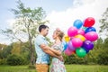 Summer holidays, celebration and dating concept - couple with colorful balloons in nature Royalty Free Stock Photo