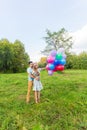 Summer holidays, celebration and dating concept - couple with colorful balloons in nature Royalty Free Stock Photo